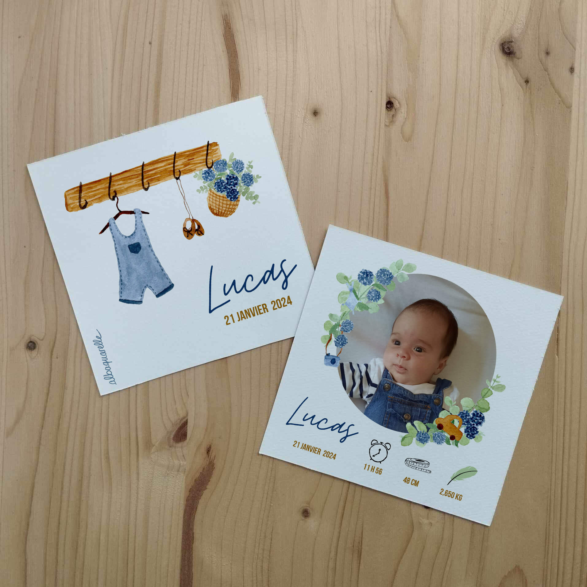 Faire part pour la naissance d'un petit garçon illustré à l'aquarelle avec un porte manteau en bois, une salopette en jean et un panier d'hortensia