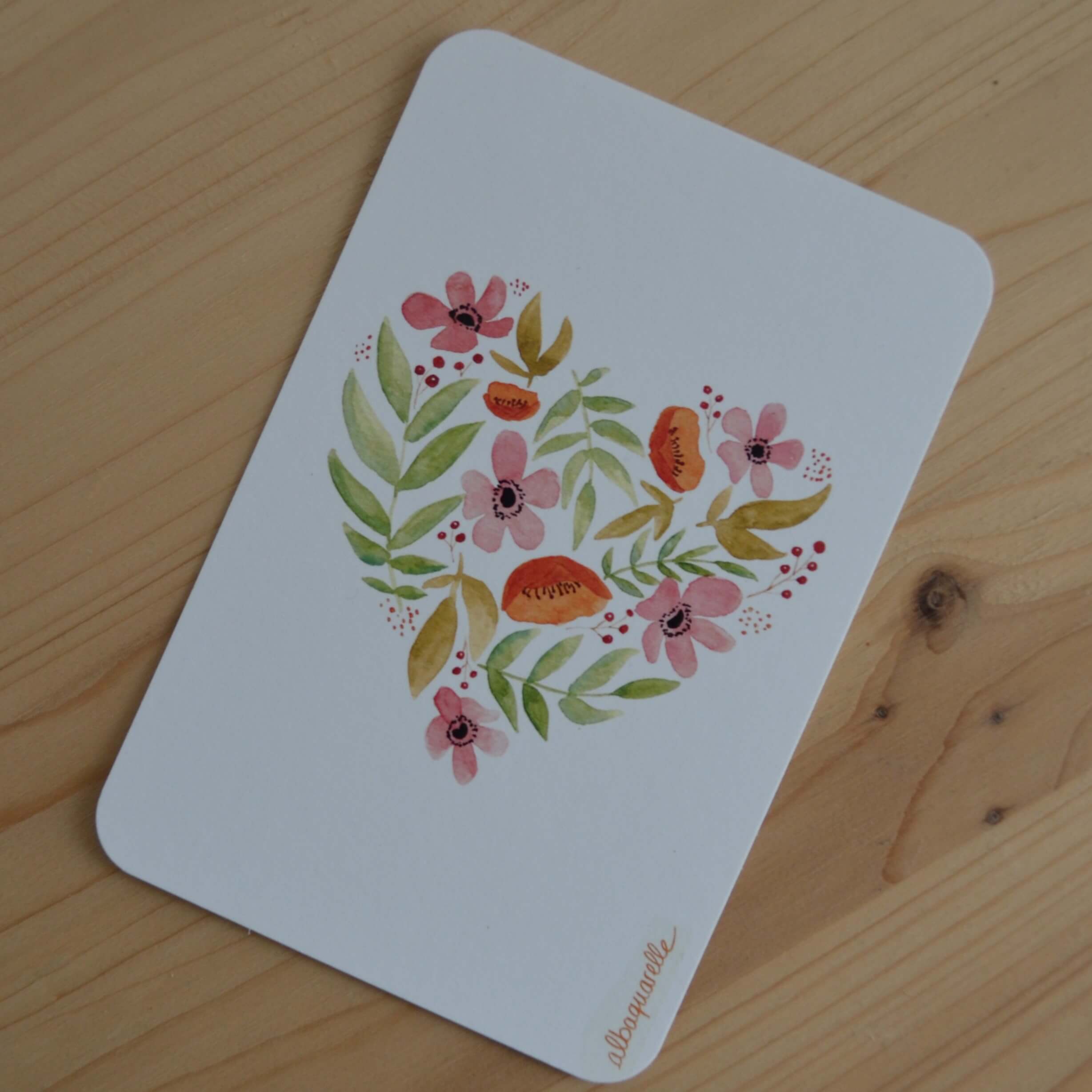 carte postale illustrée à l'aquarelle représentant des fleurs et végétaux dans une forme de coeur. Carte coeur fleuri