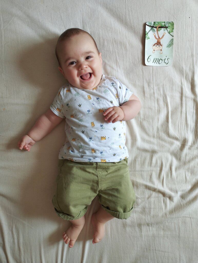 bébé photographié avec des cartes étapes illustrées à l'aquarelle
